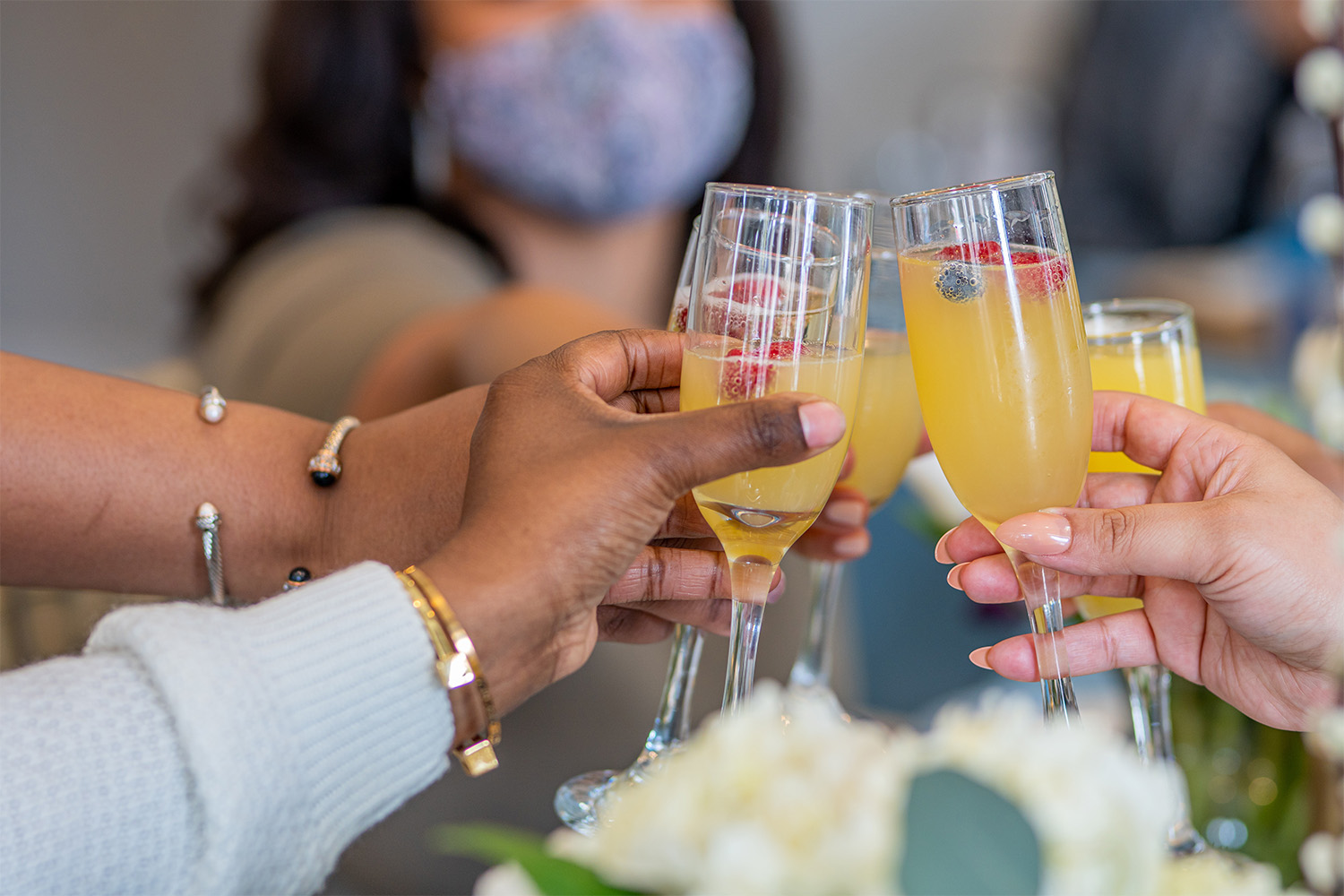 several people toasting glasses of mimosa 