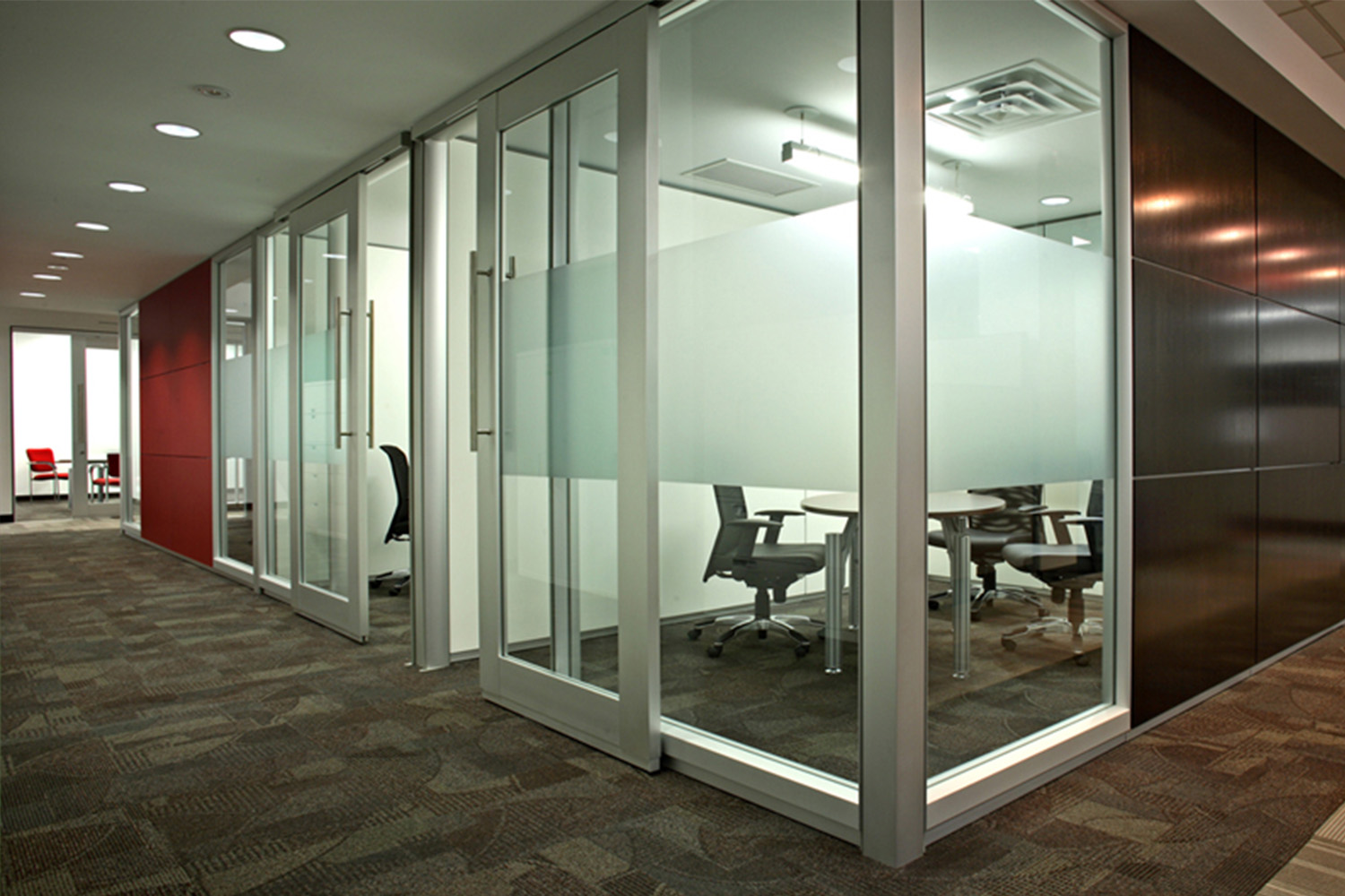 view of an office space with large glass walls, seen at a corner