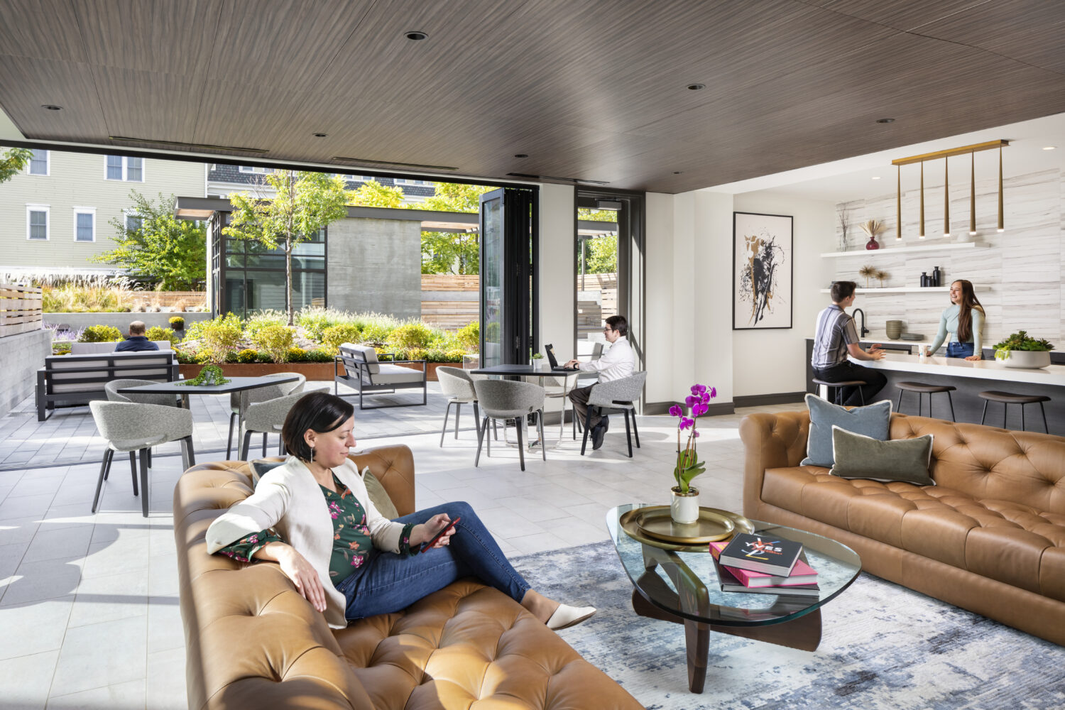 Lounge area of Flats on First, with people sitting on couches 