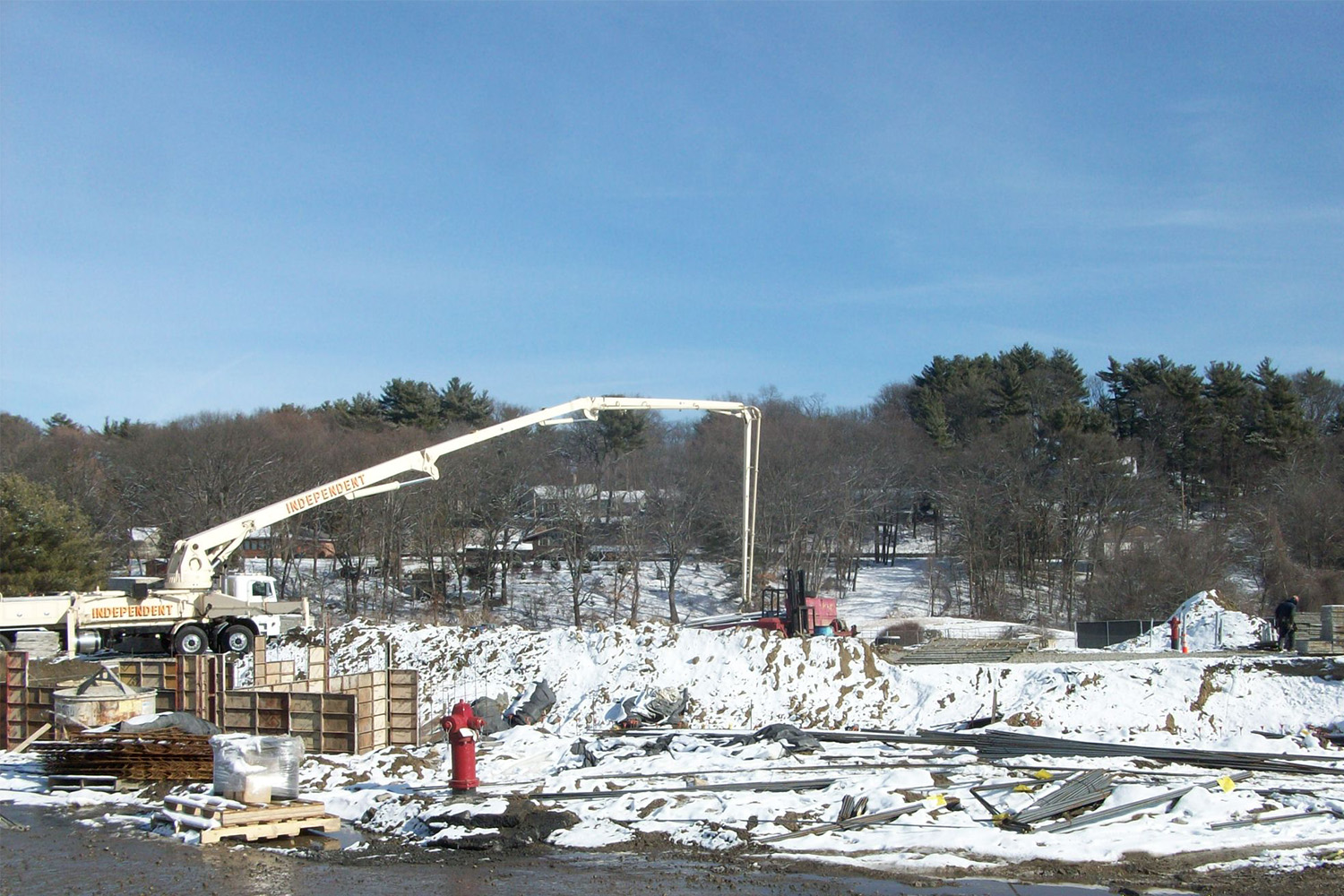 snow-covered construction area, with crane in the background 