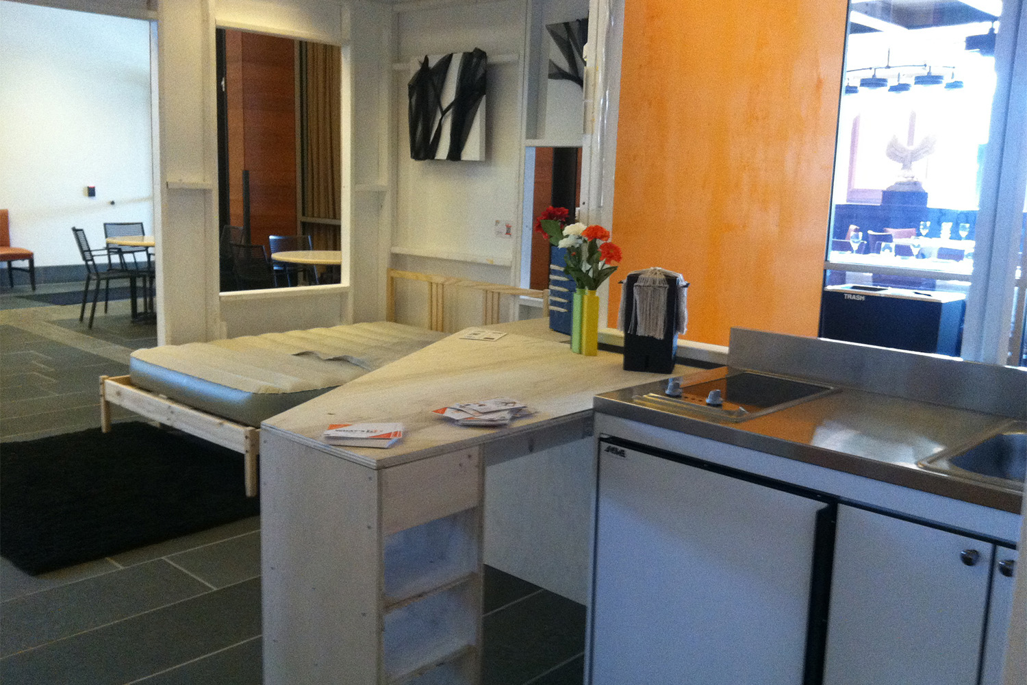 micro unite with living room,, bed, kitchenette, and windows