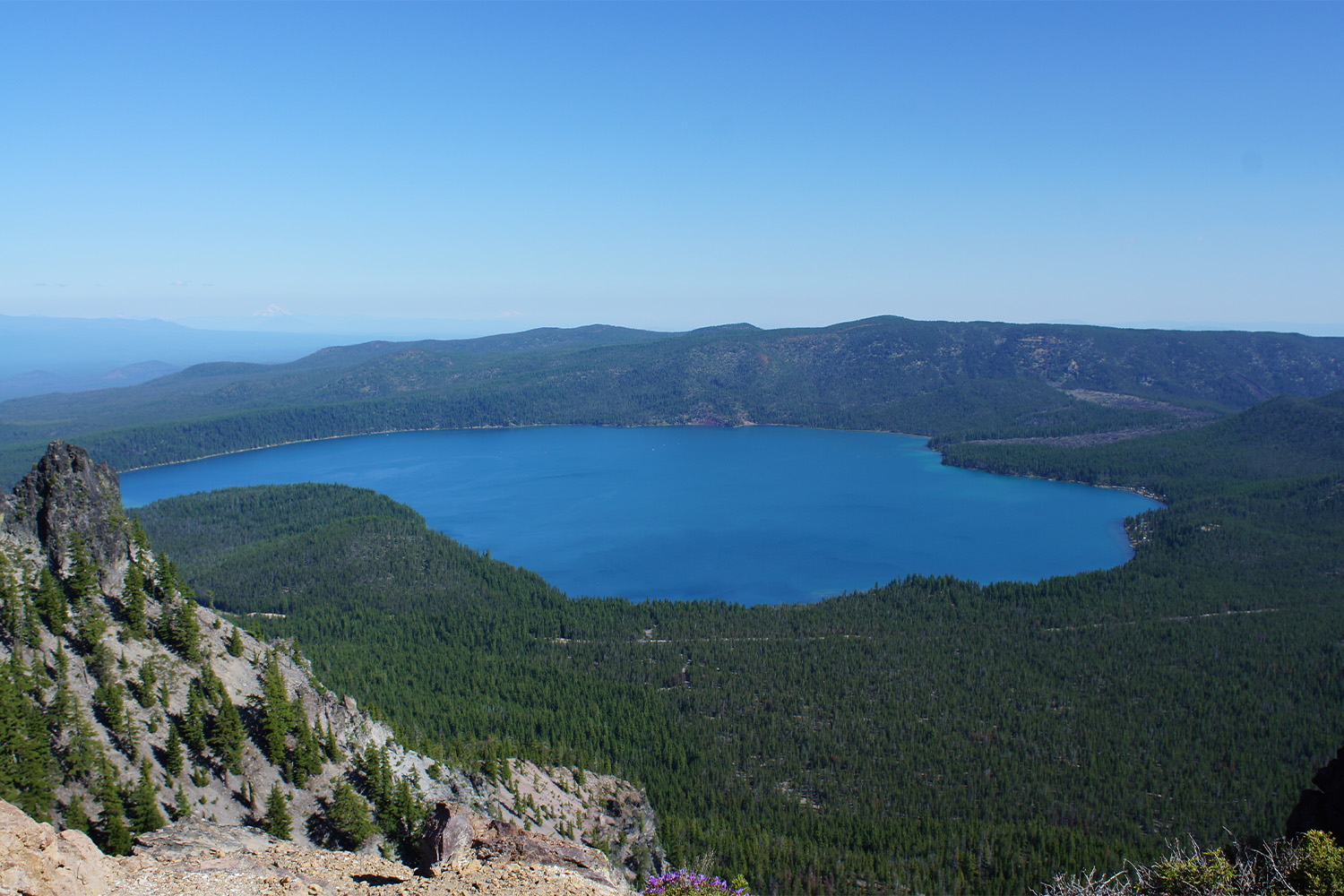 View of Newberry Volcano National Park, seen from a rock ledge. Phot includes view of crater lake.