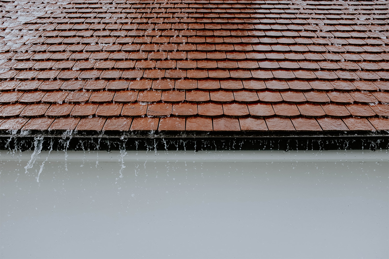 tiled roof with water running into drain 
