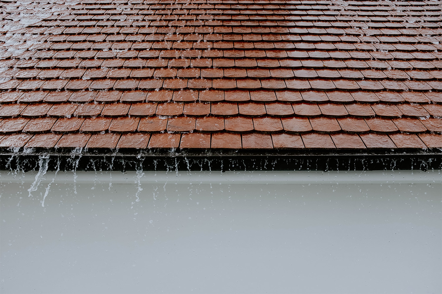 tiled roof with water running into drain