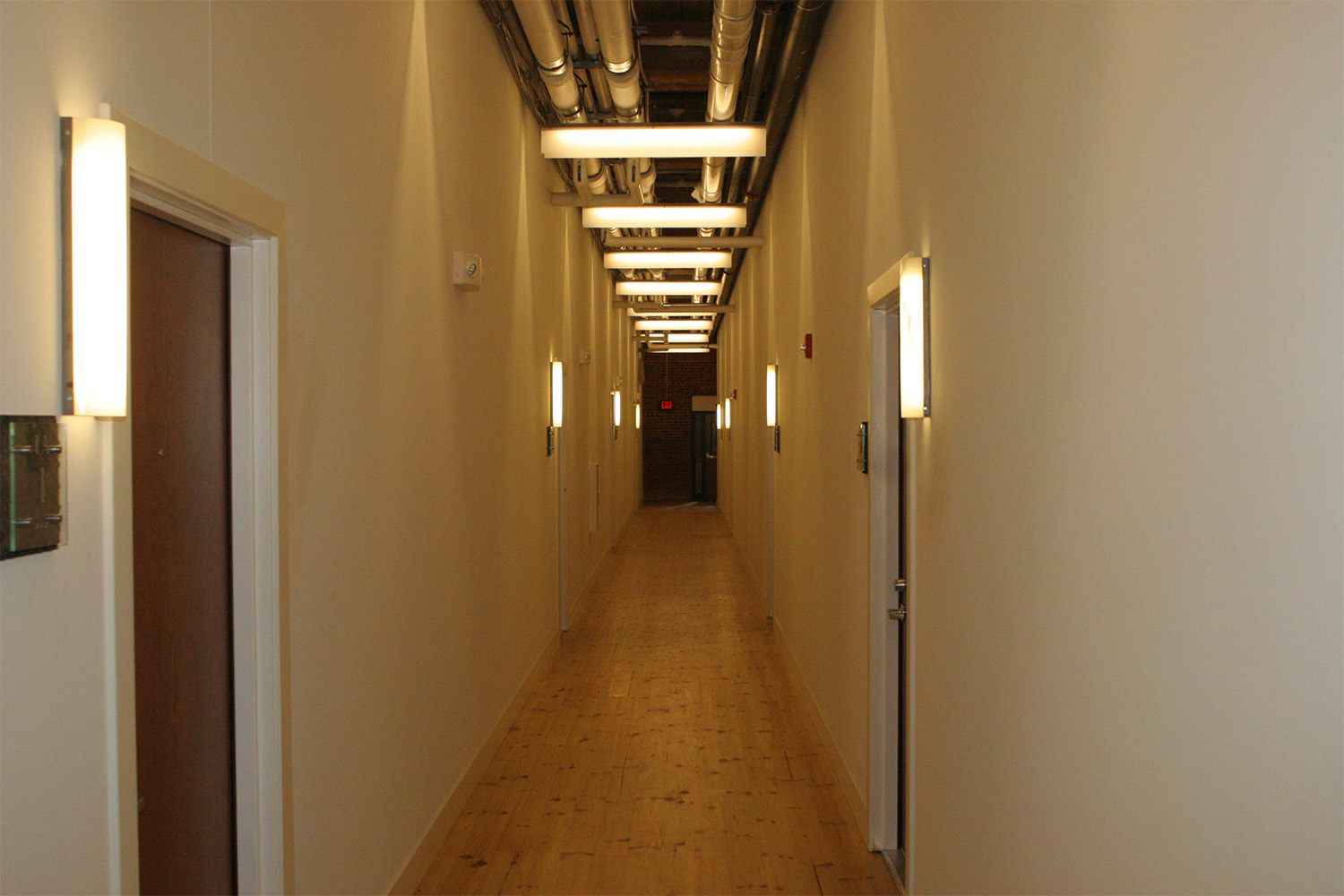 long hallway with light sconces on both sides 