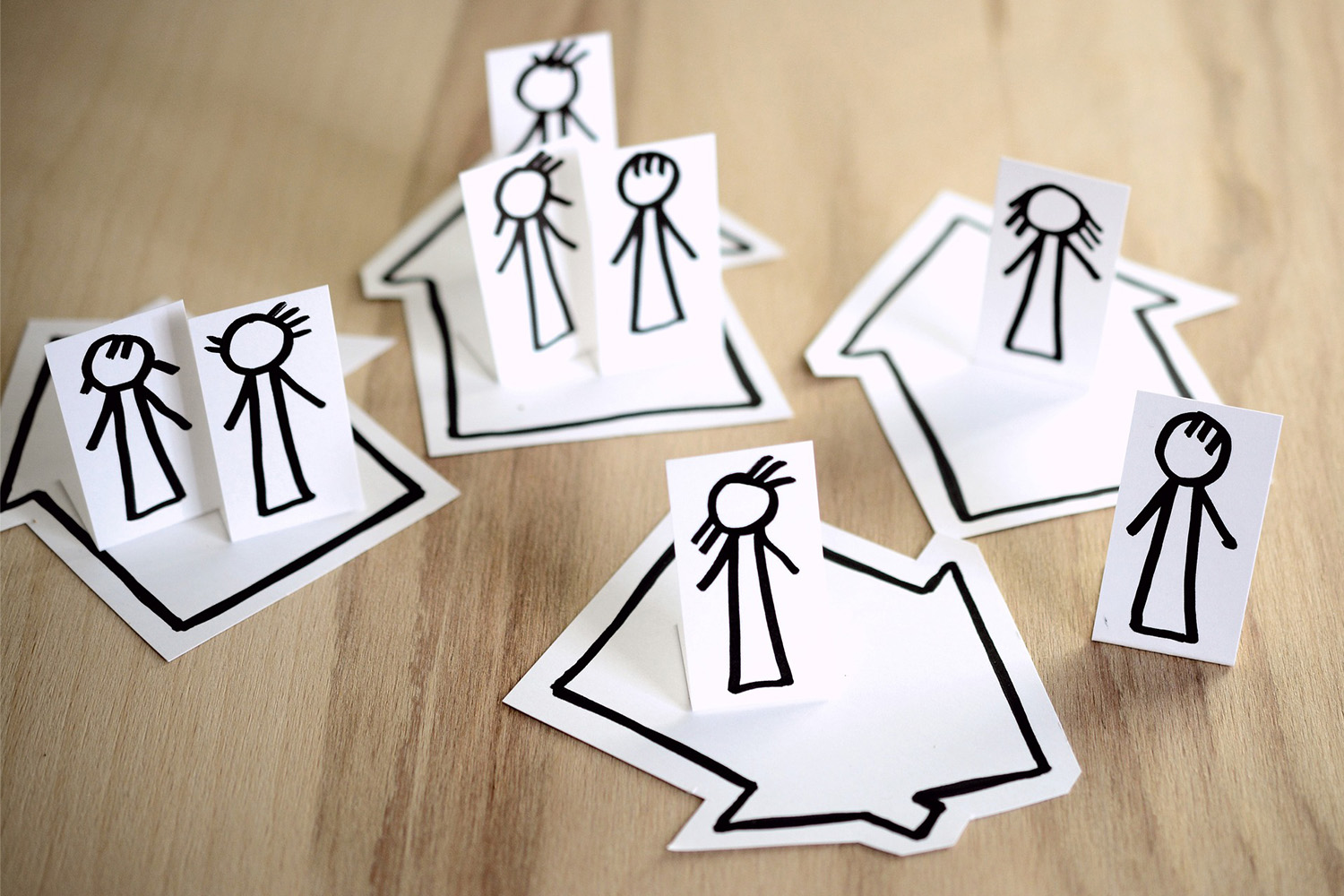 paper cut outs of stick drawings in houses