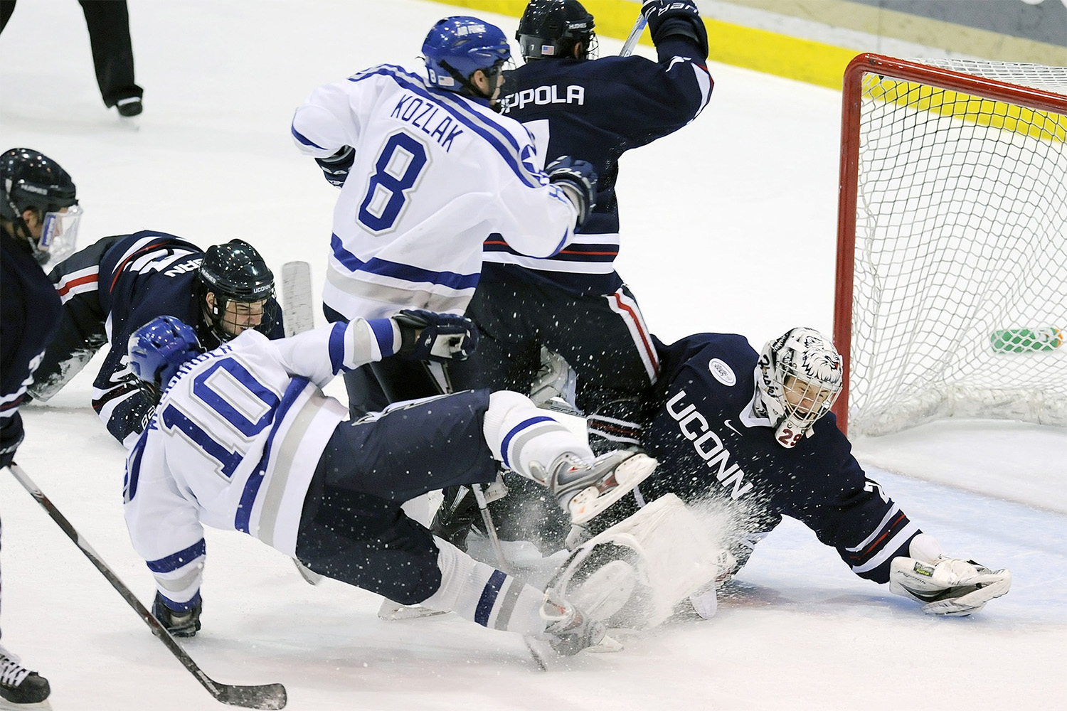 several hockey players on an ice rink, crashing into each other 