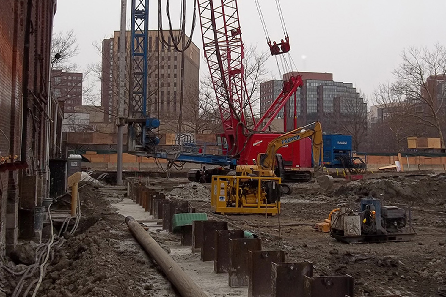 red hydraulic lift outside of Binney, with soil wall installation