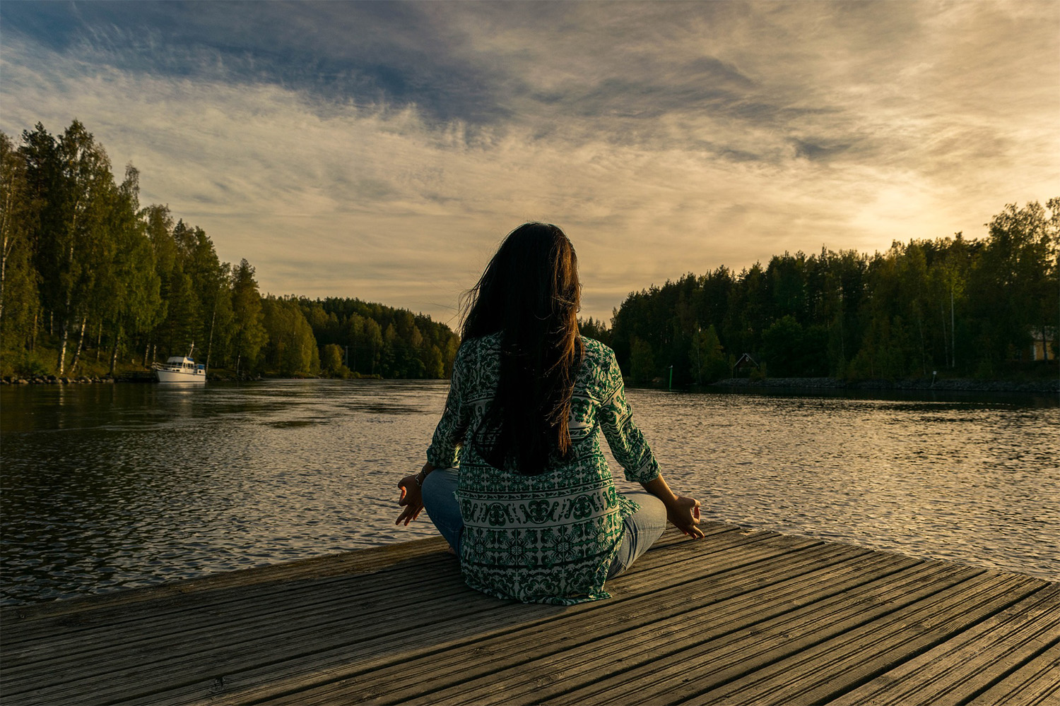 woman meditating in yoga pose on a dock 