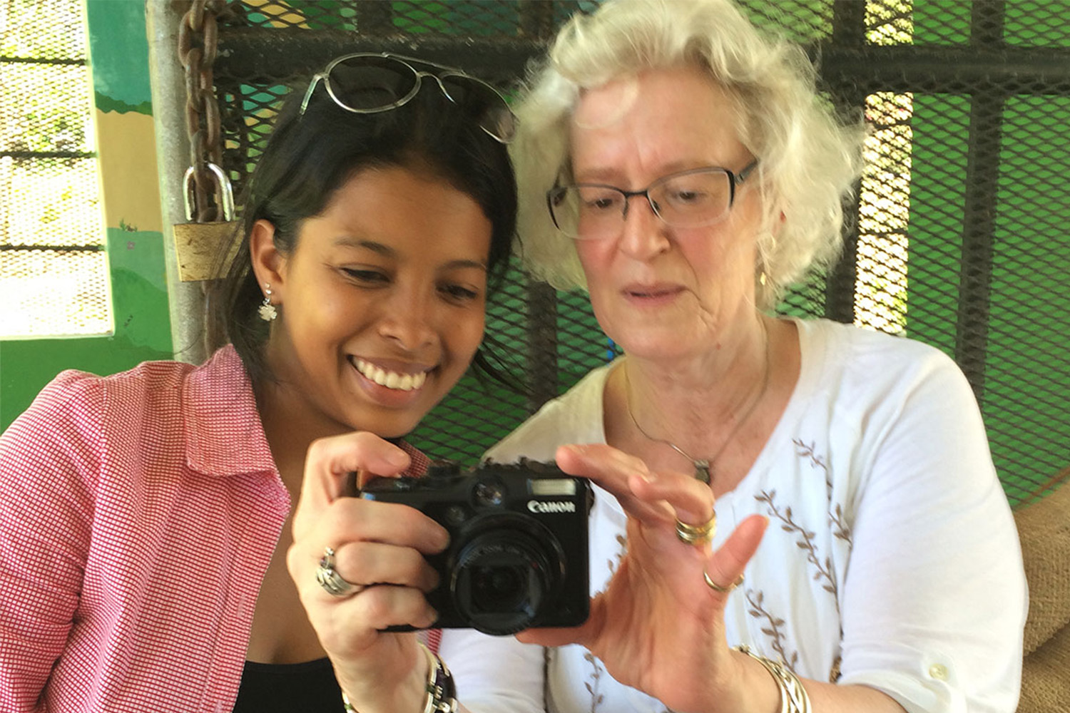 Amy teaches Esmeralda how to use a camera, explaining its functions 