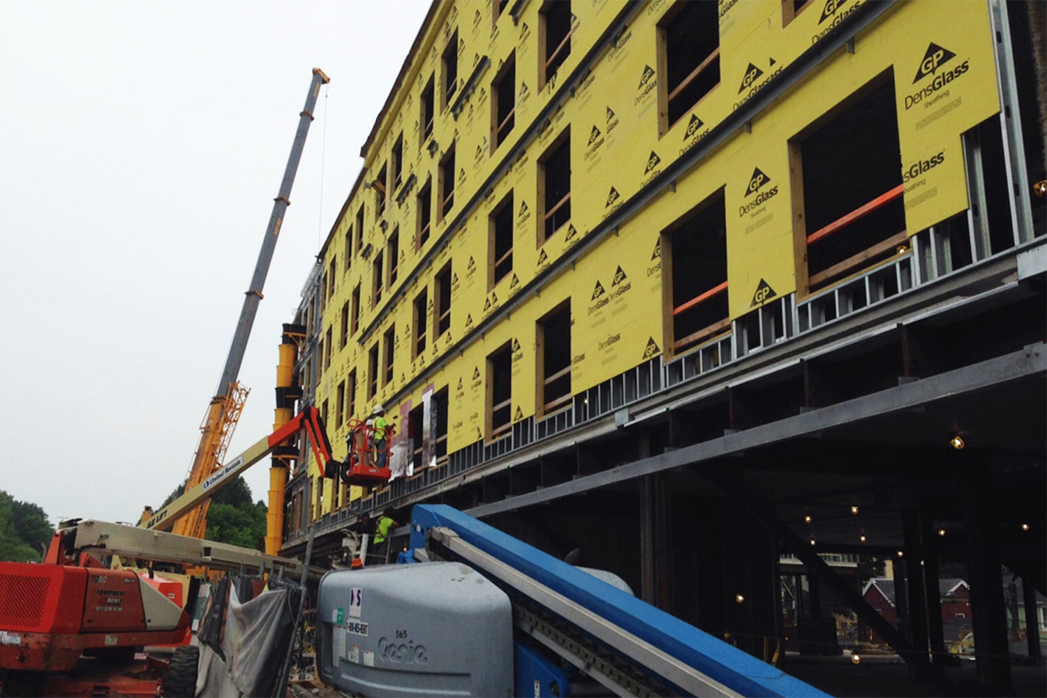 building with yellow paneling, hydraulic lift seen to the left