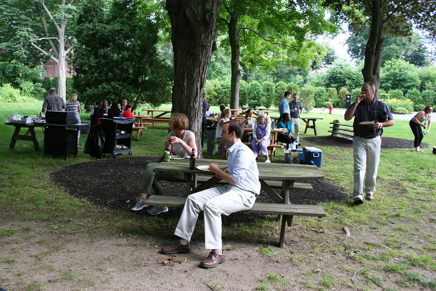 people watch others play Bocce ball, as they enjoy their food 