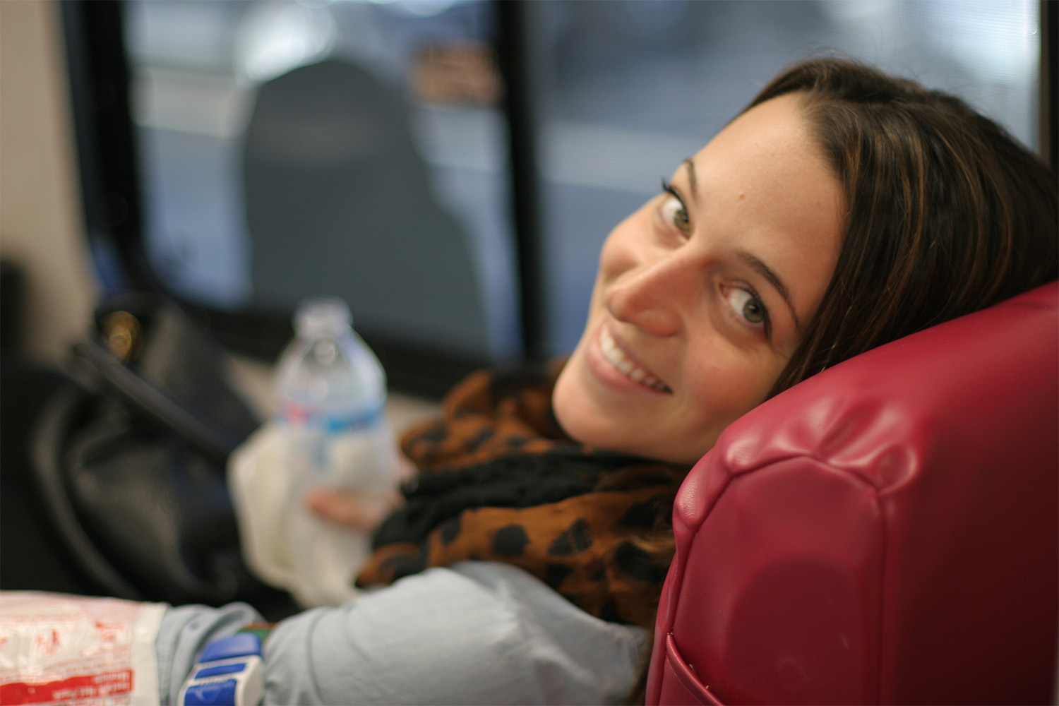 Tia takes a break from hydrating while giving blood to smile for the camera.