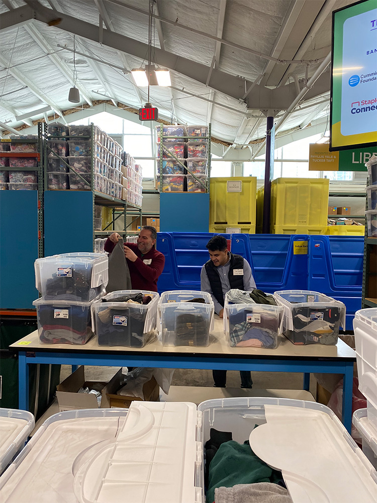 James and Ben sorting through bins of clothes 