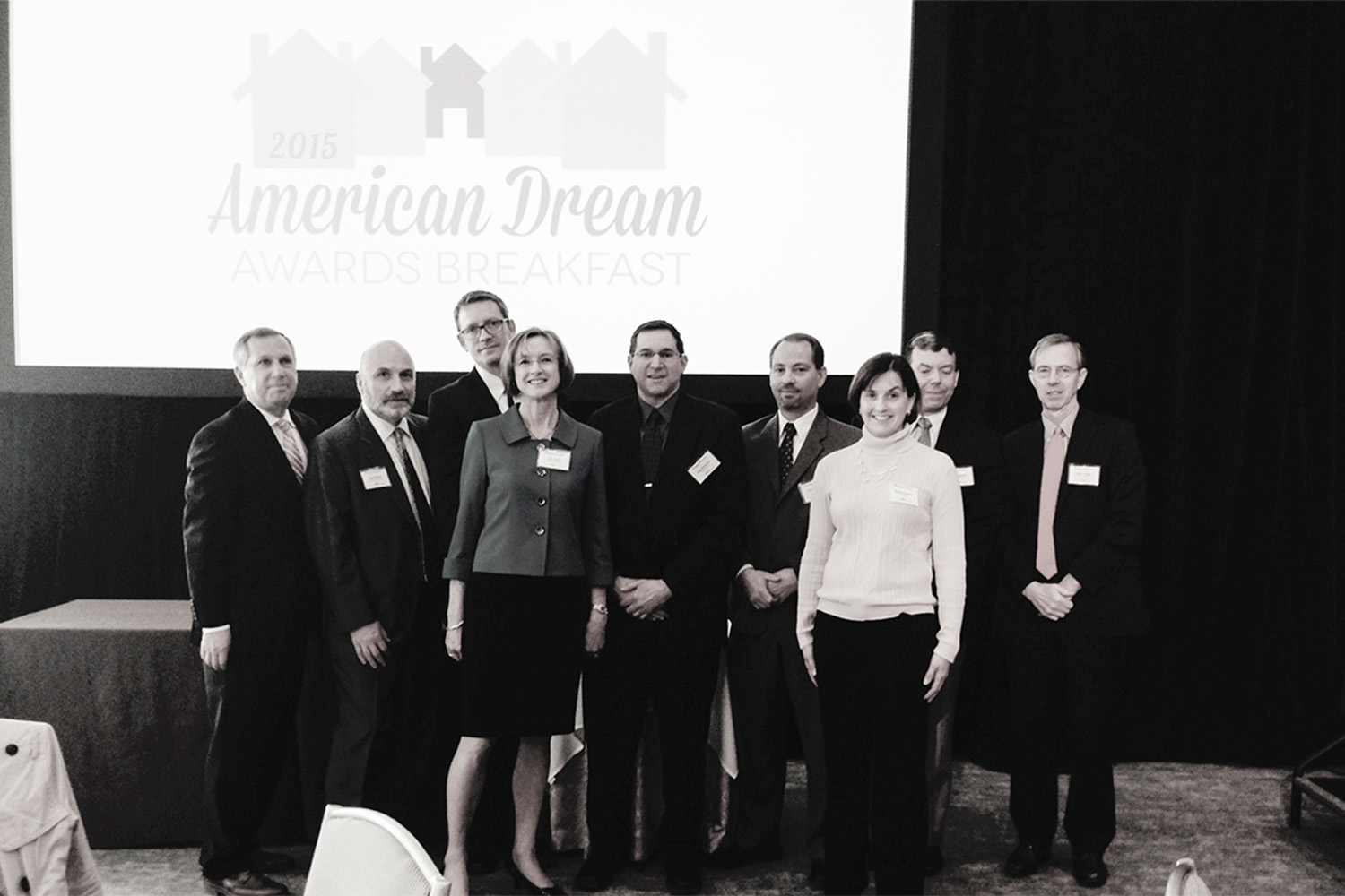 black and white photo of Tocci employees posing for group  photo at the 2015 American Dream Breakfast 