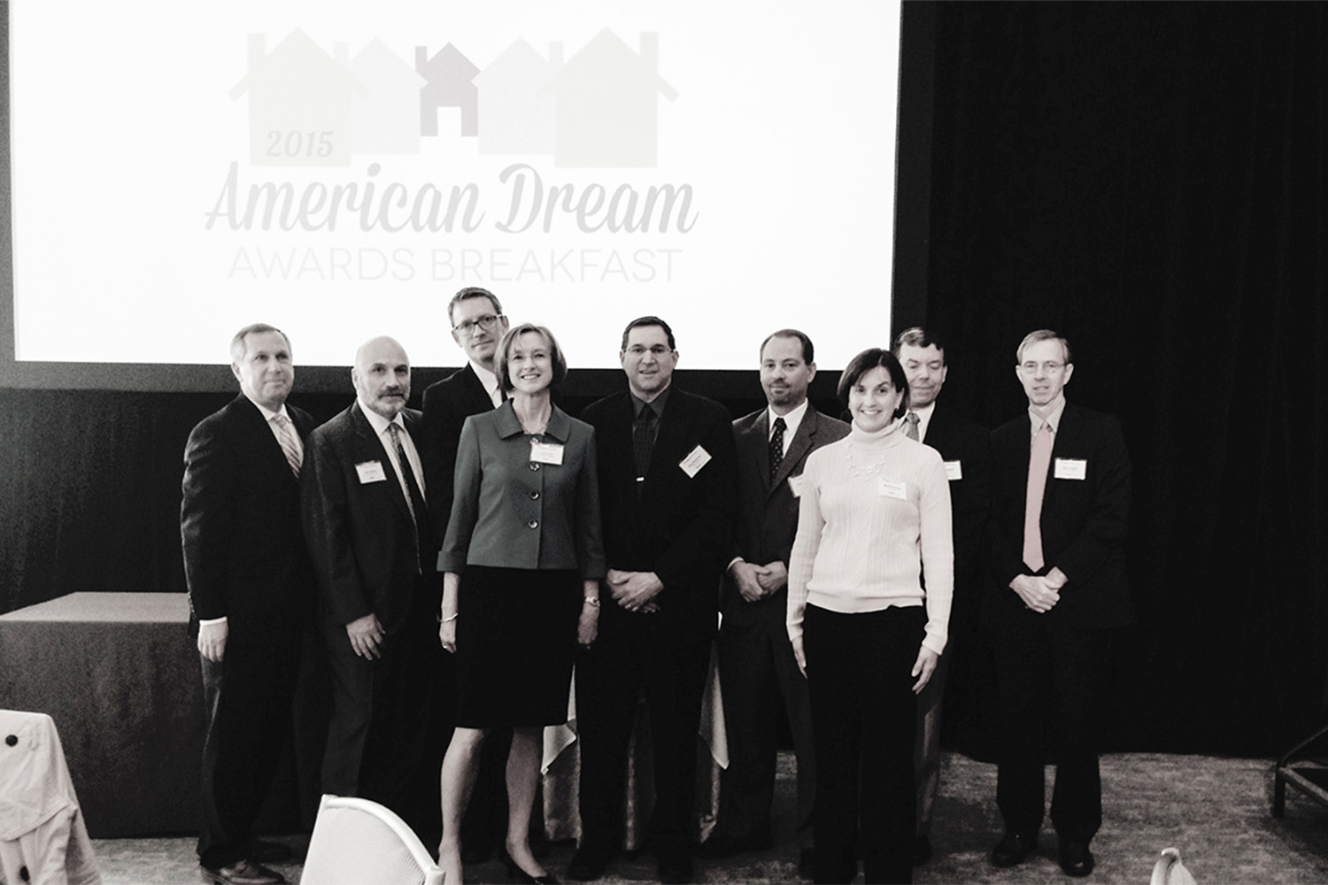 black and white photo of Tocci employees posing for group photo at the 2015 American Dream Breakfast
