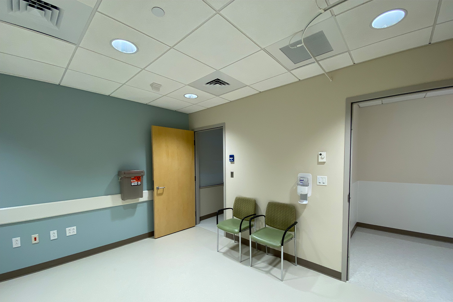 empty examination room with two green chairs