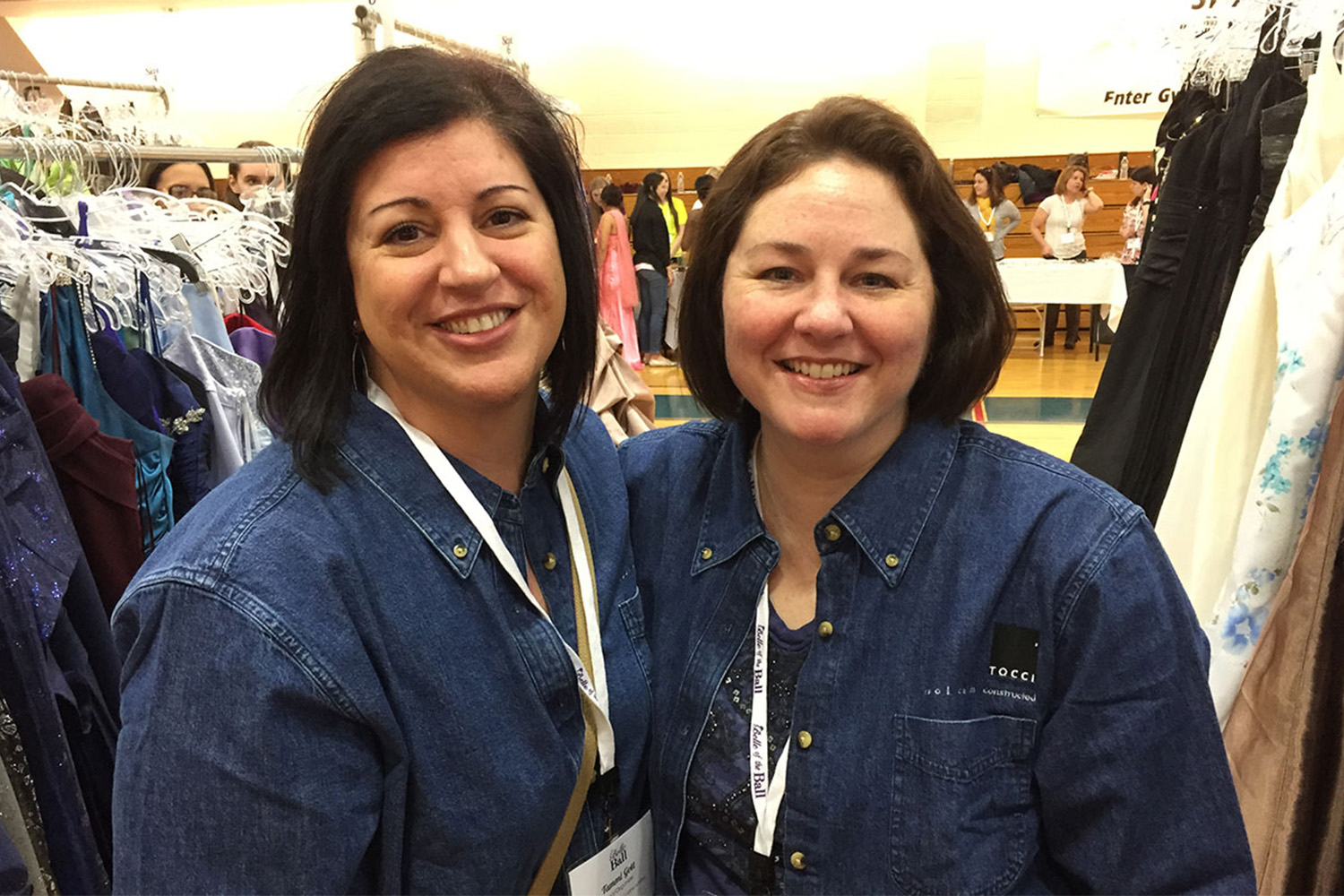 Tammi and her friend pose for photo between dress racks