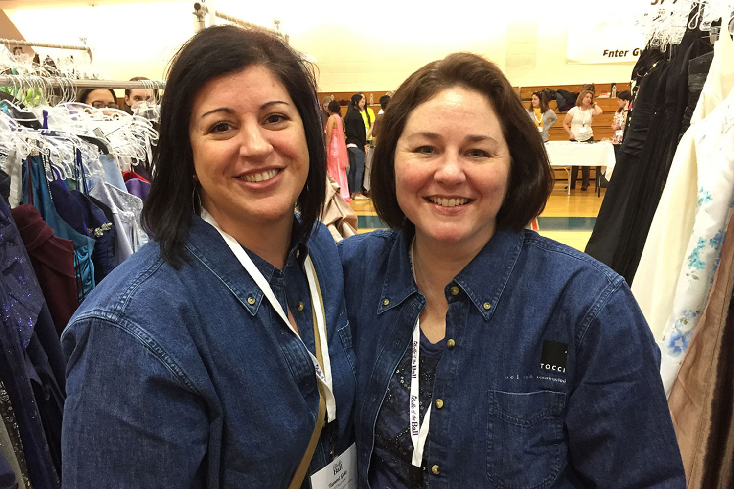 Tammi and her friend pose for photo between dress racks 