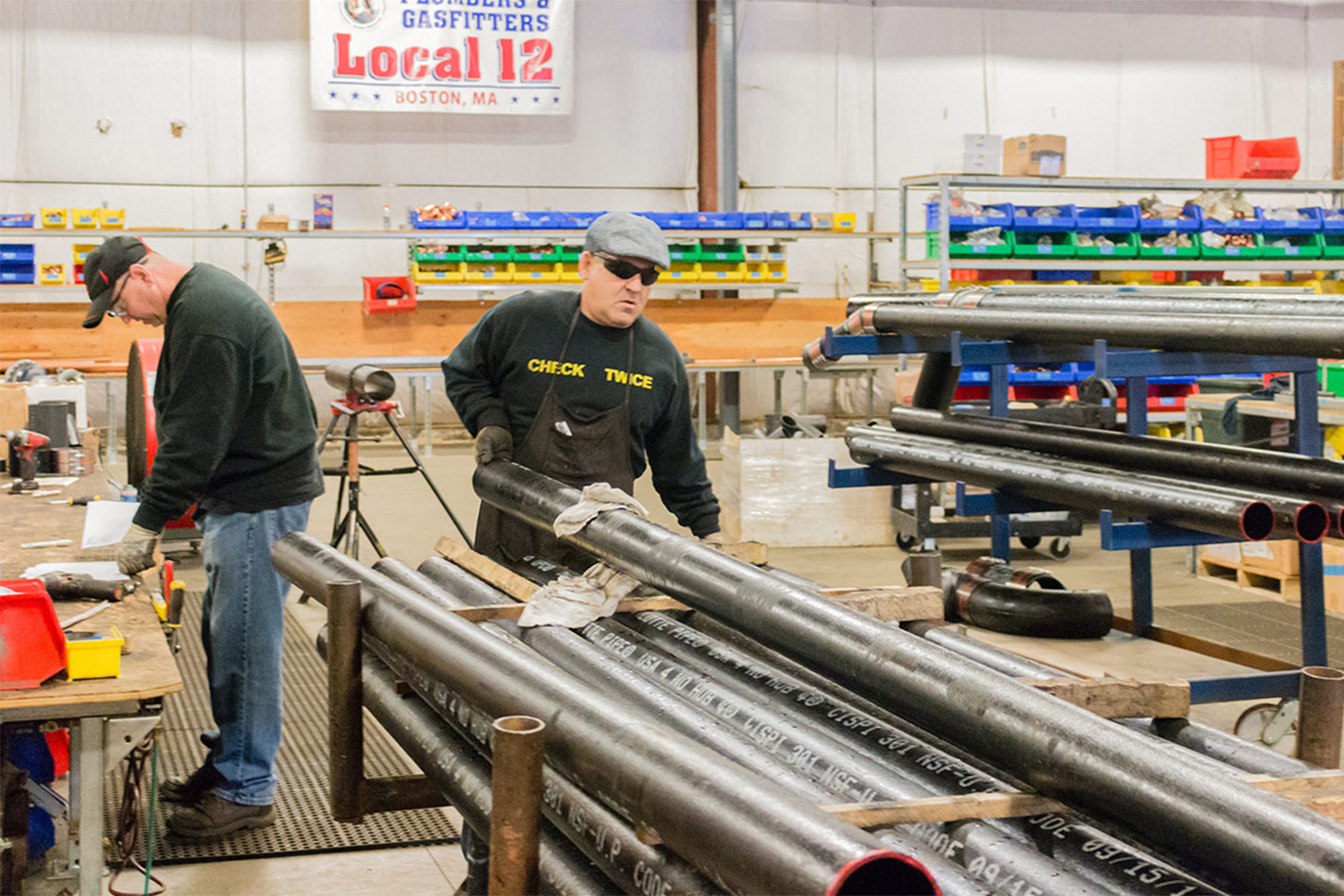 Two prefab workers handles metal beams