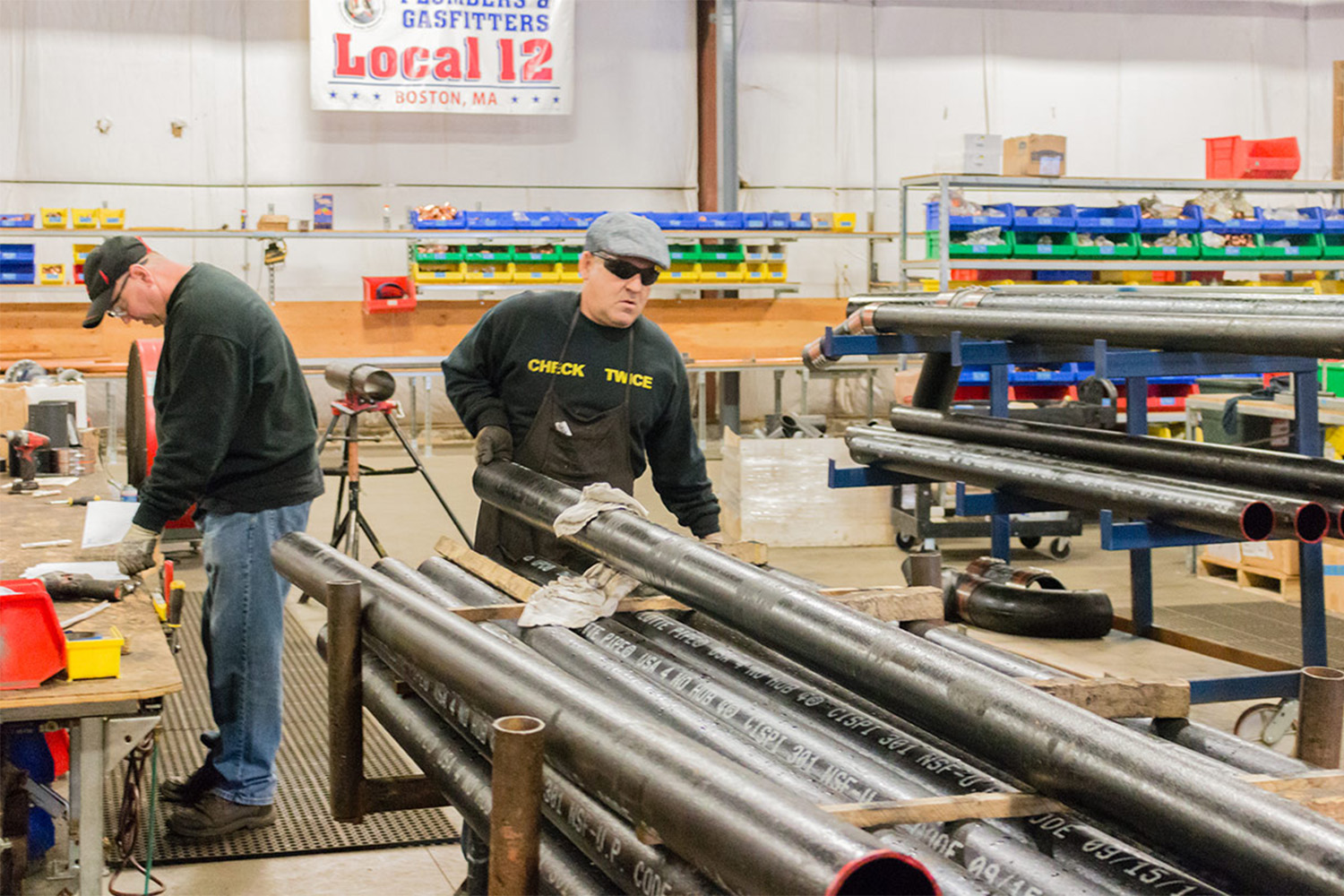 Two prefab workers handles metal beams 