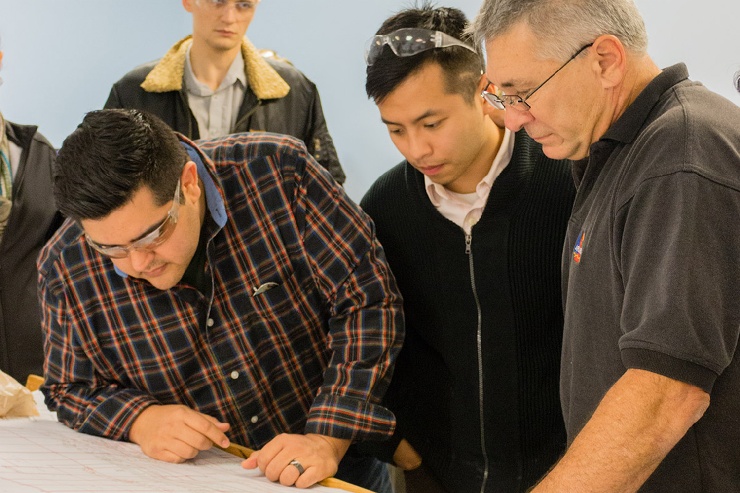 three men looking at a paperwork together 