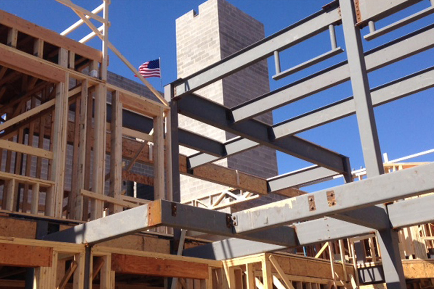 worm's eye view of building frame, with American flag waving