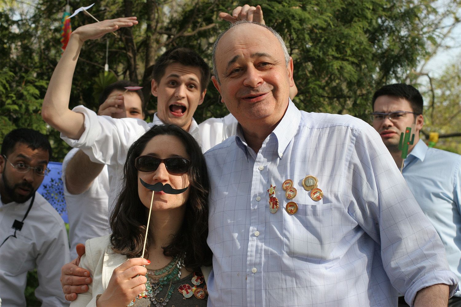 Laura and Victor posing for photo with fake mustache 