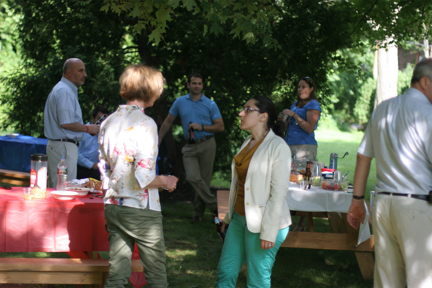 Tocci staff chatting around a long picnic table with various foods and drinks on top