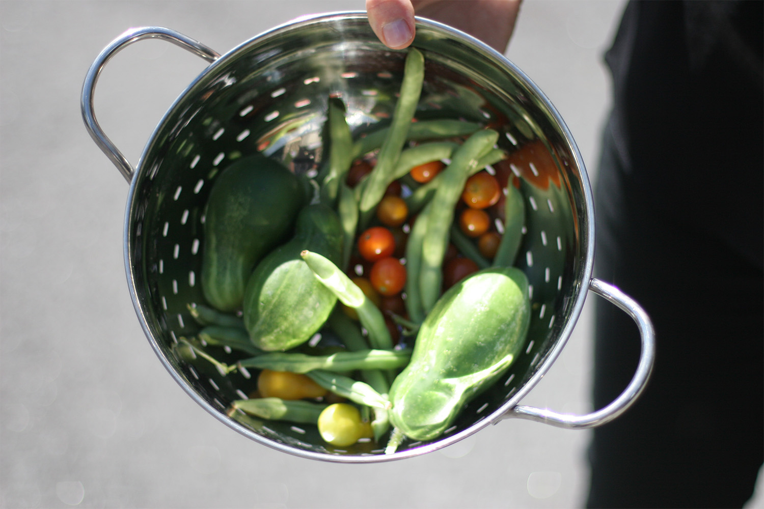 A metal strainers with various vegetables inside 