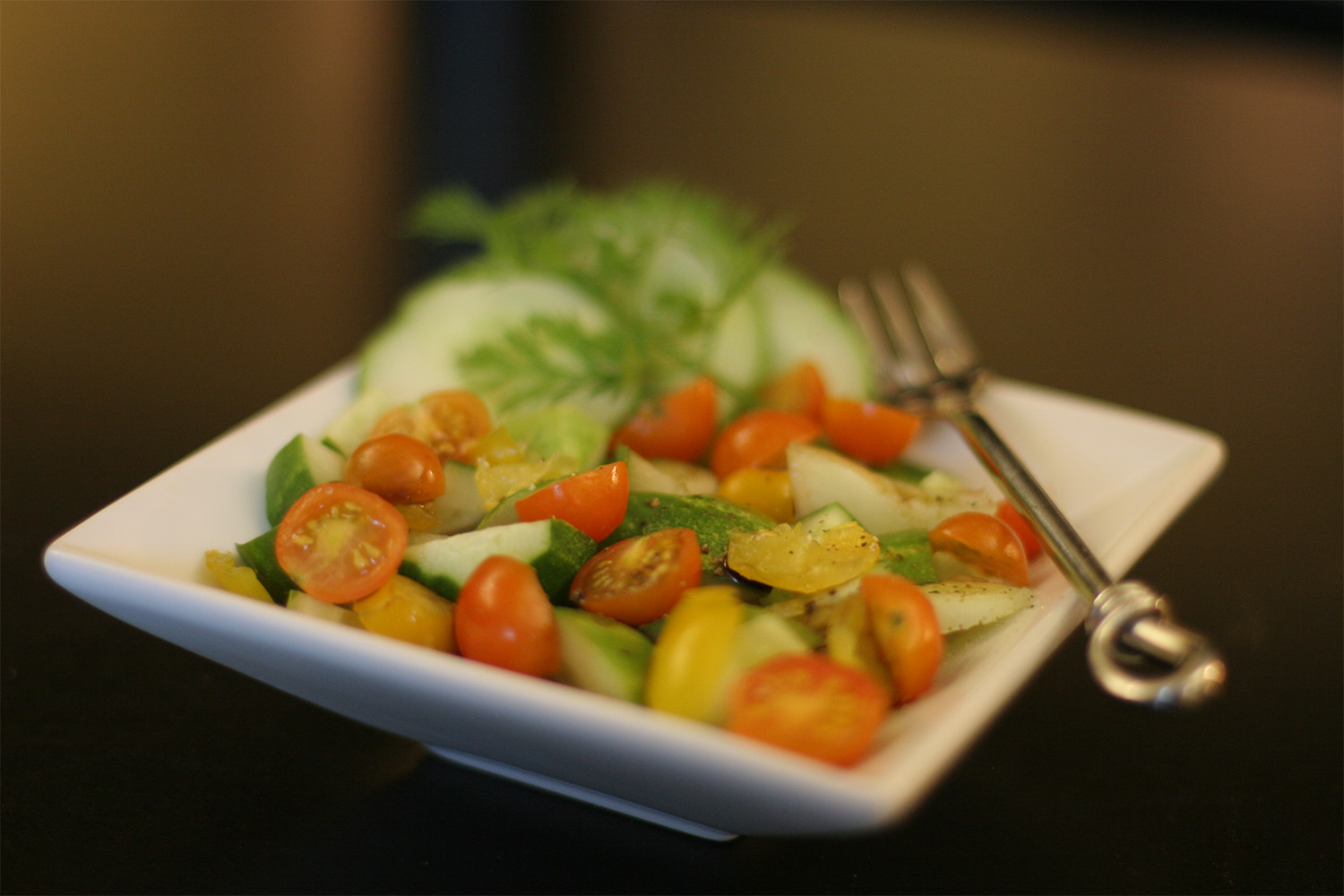 a square plate with sliced cherry tomatoes on top 