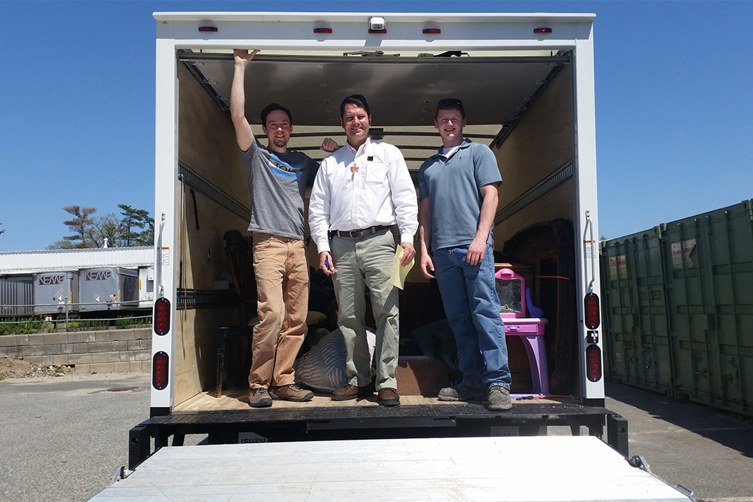 L to R: Ryan, VJ, + Caleb standing in the entrance of a truck 