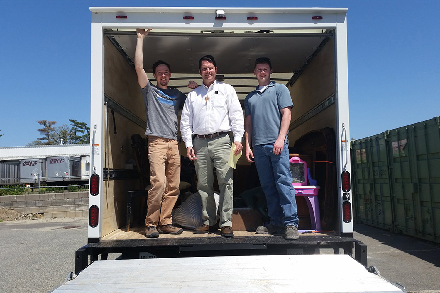 L to R: Ryan, VJ, + Caleb standing in the entrance of a truck