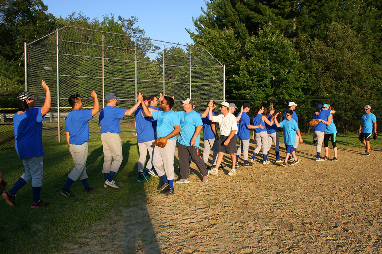 Tocci employees line up to give handshakes after the softball game 