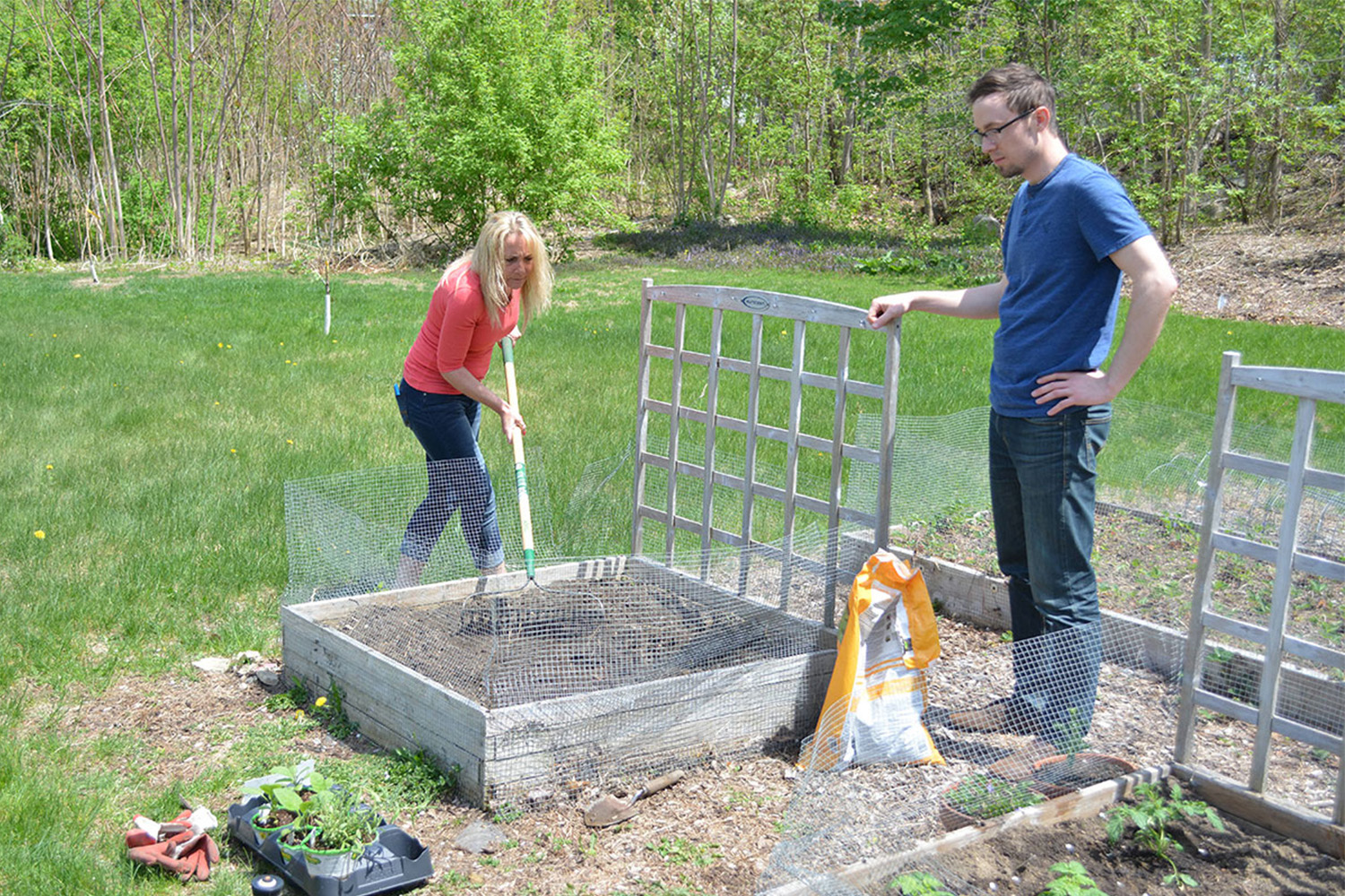 Joann and Caleb get the garden bed ready for planting.