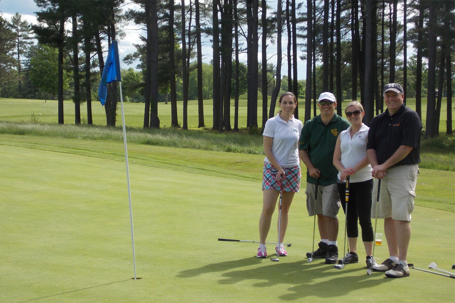 4 Tocci employees pose for group photo on the golf course 