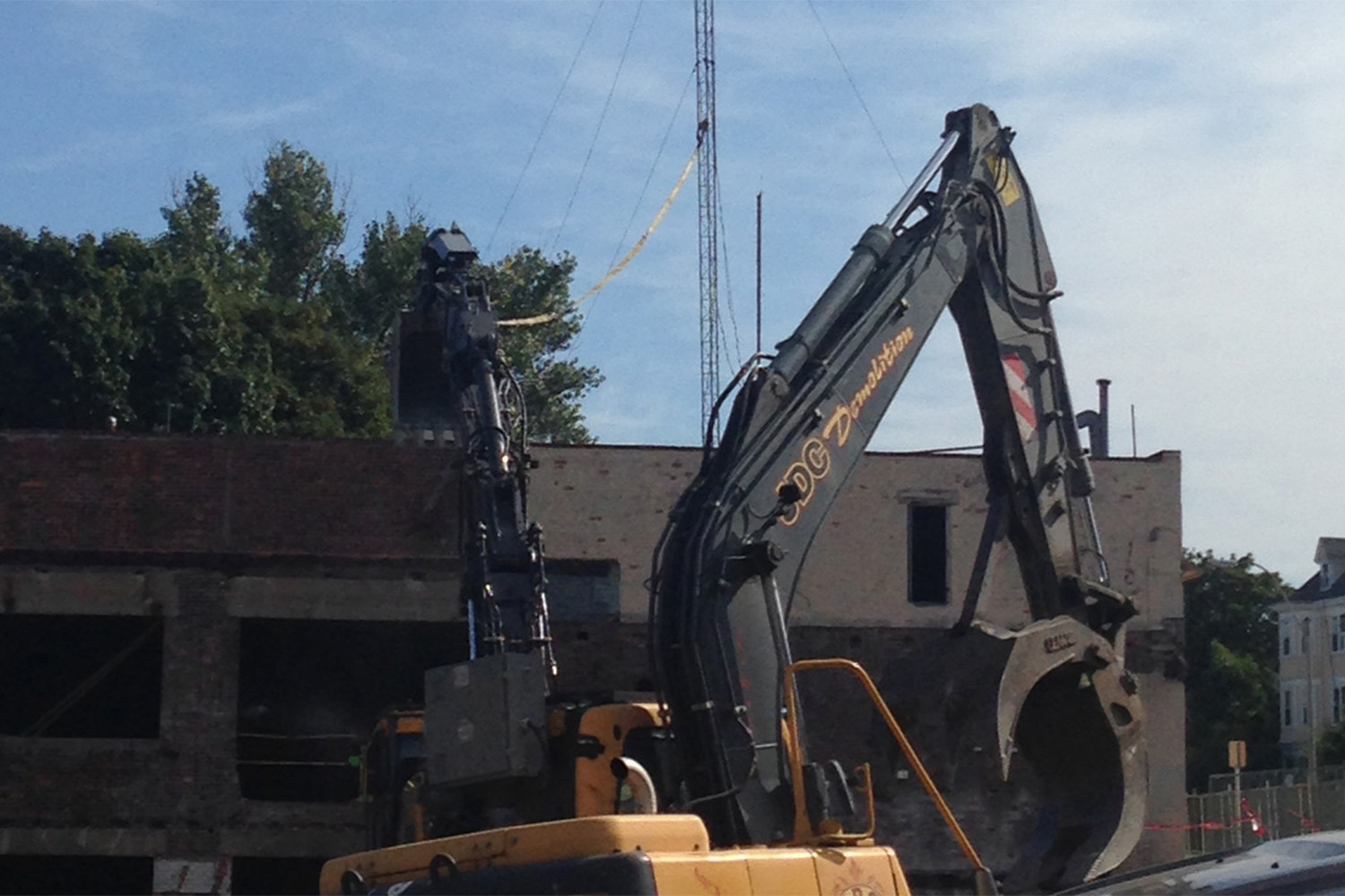 Excavator in front of brick building 