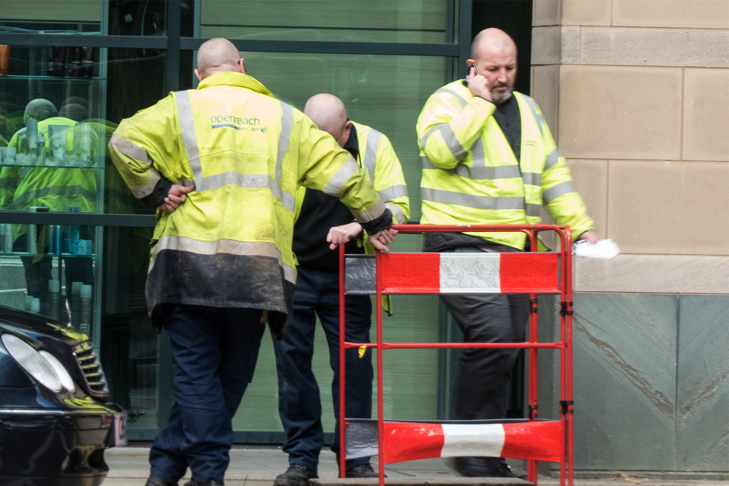 3 construction workers on their cellphones