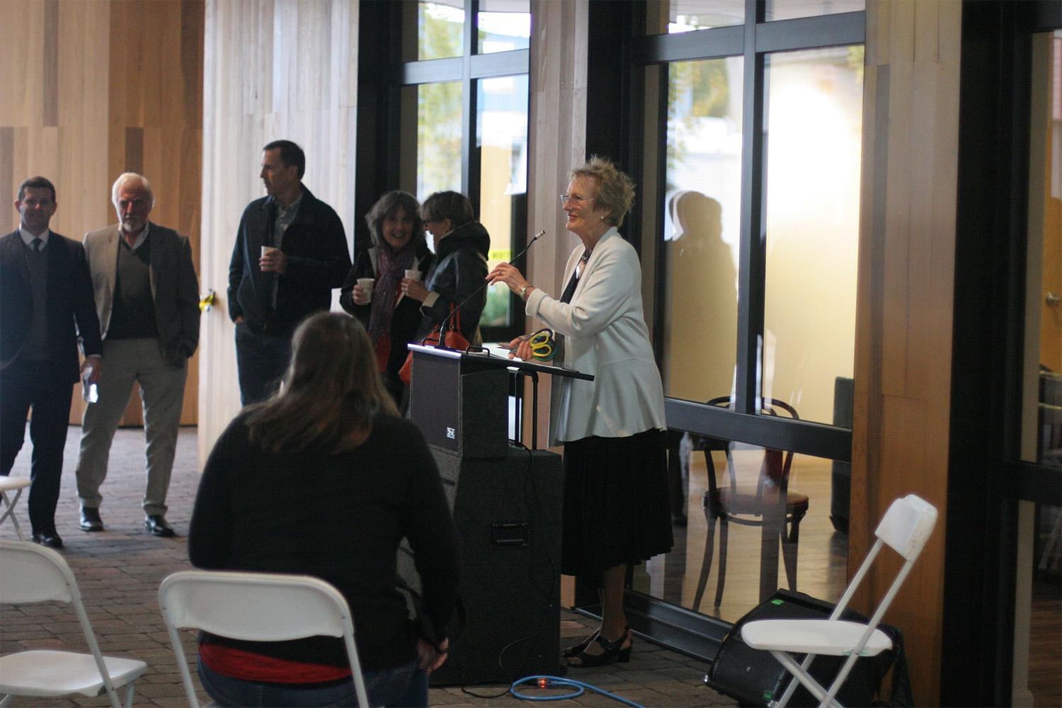 an older woman speaking from behind podium