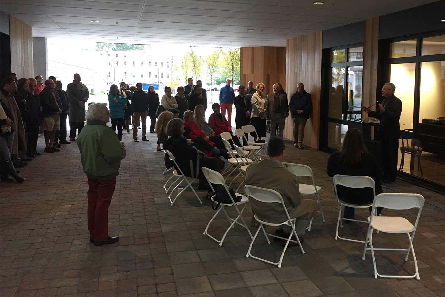 a room with a group of people facing the right direction, listening to speaker at the podium