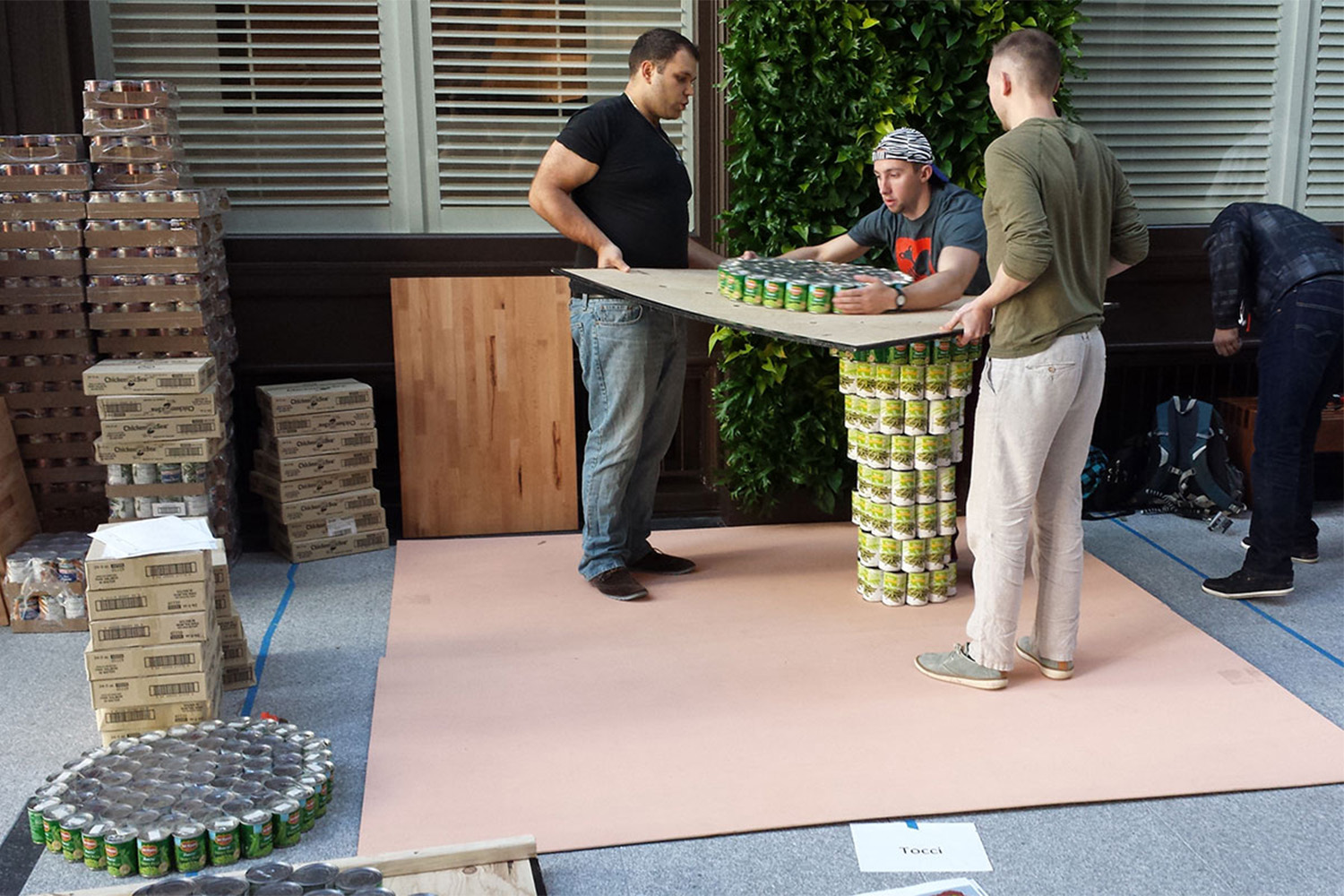 Tocci employees build a structure out of cans of food