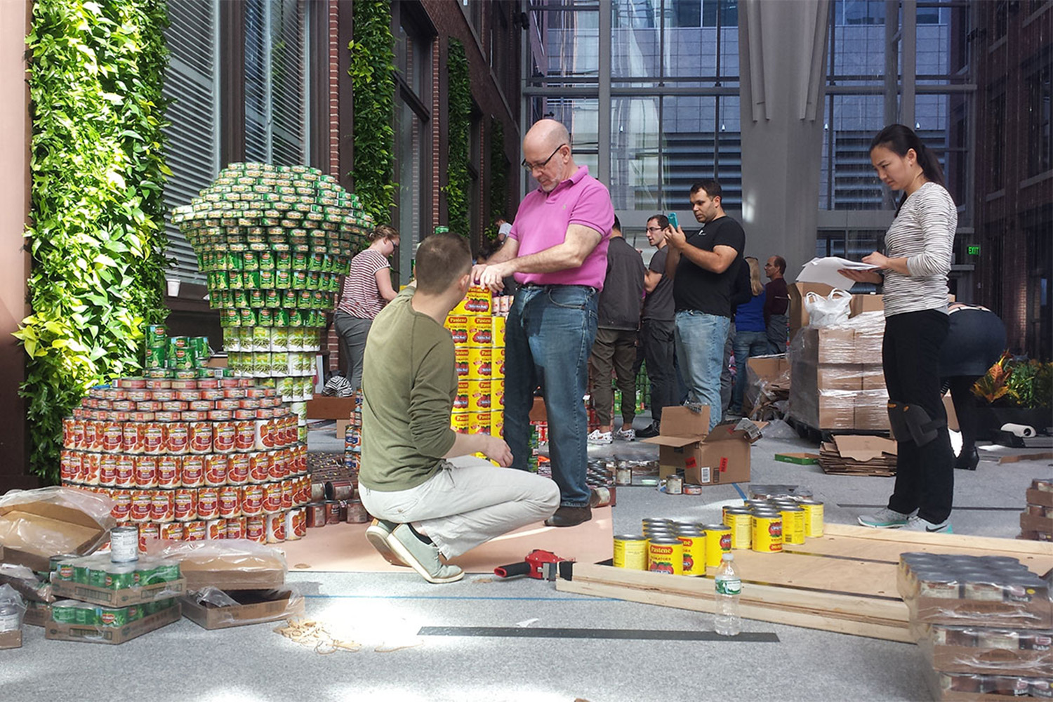 Tocci employees build a model of a corn cob, out of hundreds of food cans 