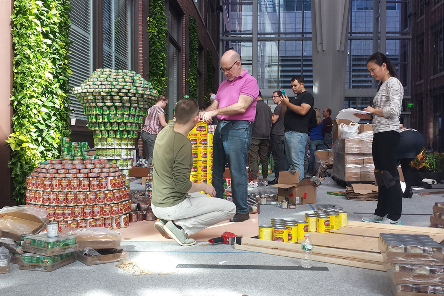 Tocci employees build a model of a corn cob, out of hundreds of food cans