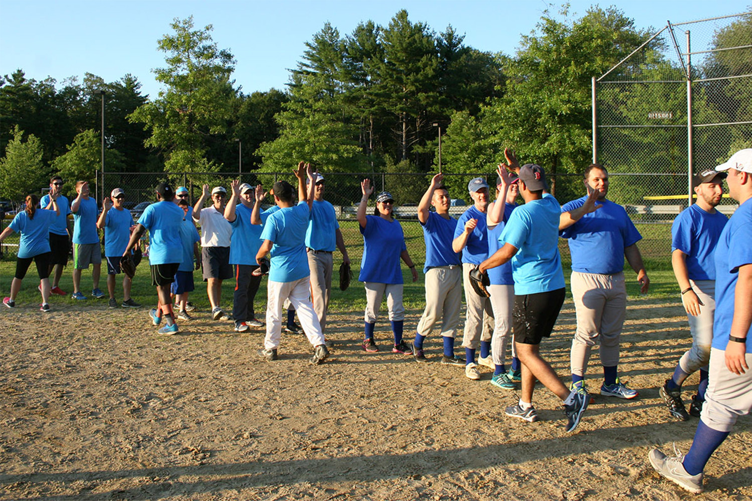 Tocci employees giving high-fives after softball game 