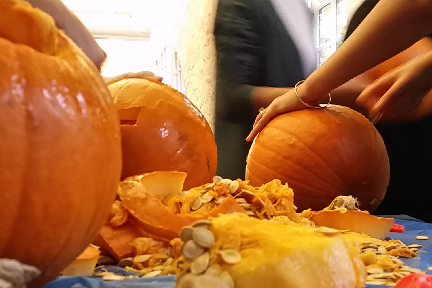 hands carving a pumpkin