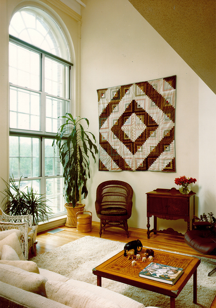 living room with tall French window, and patchwork decoration on wall 