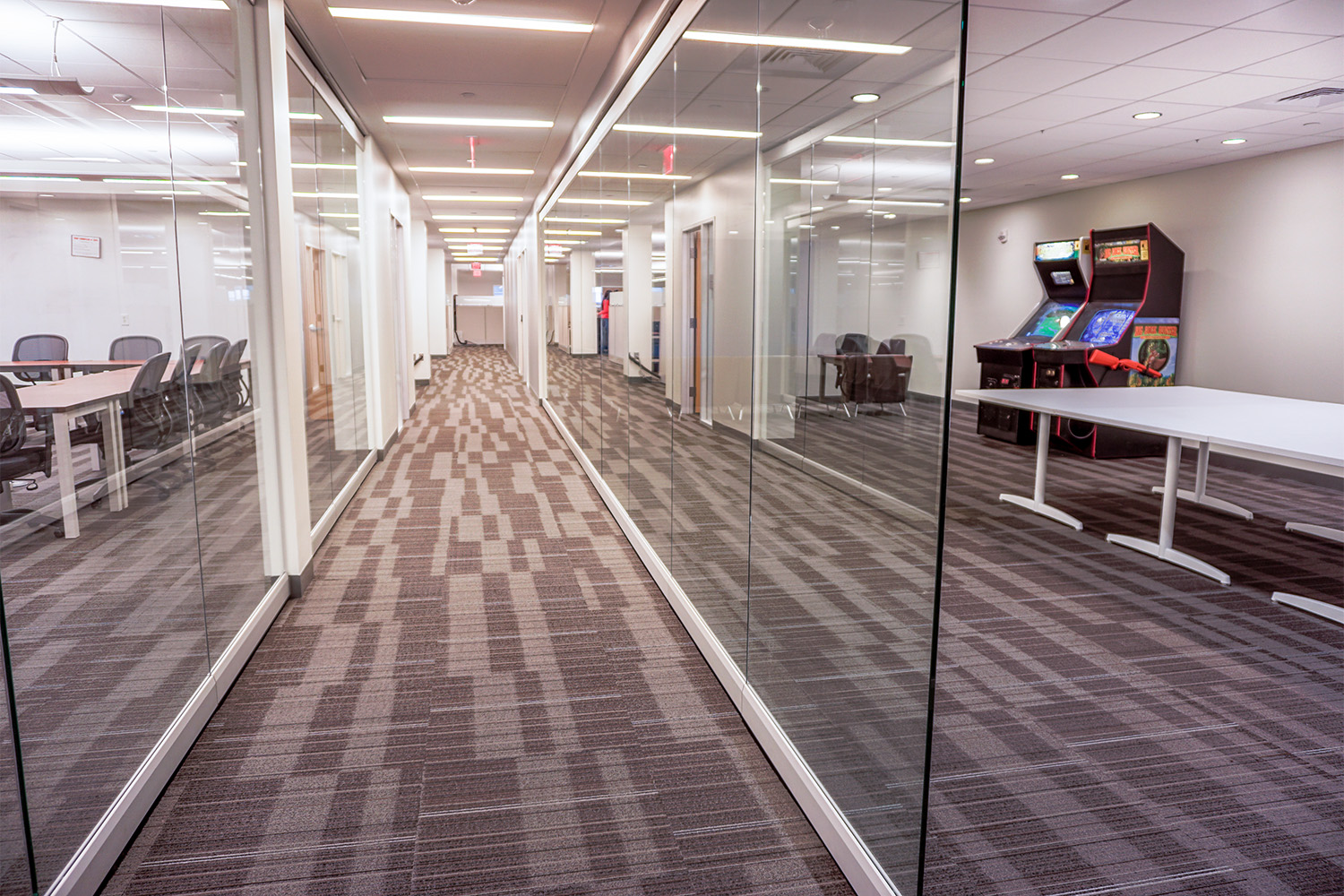 hallway with grey carpets, leading to play area of office