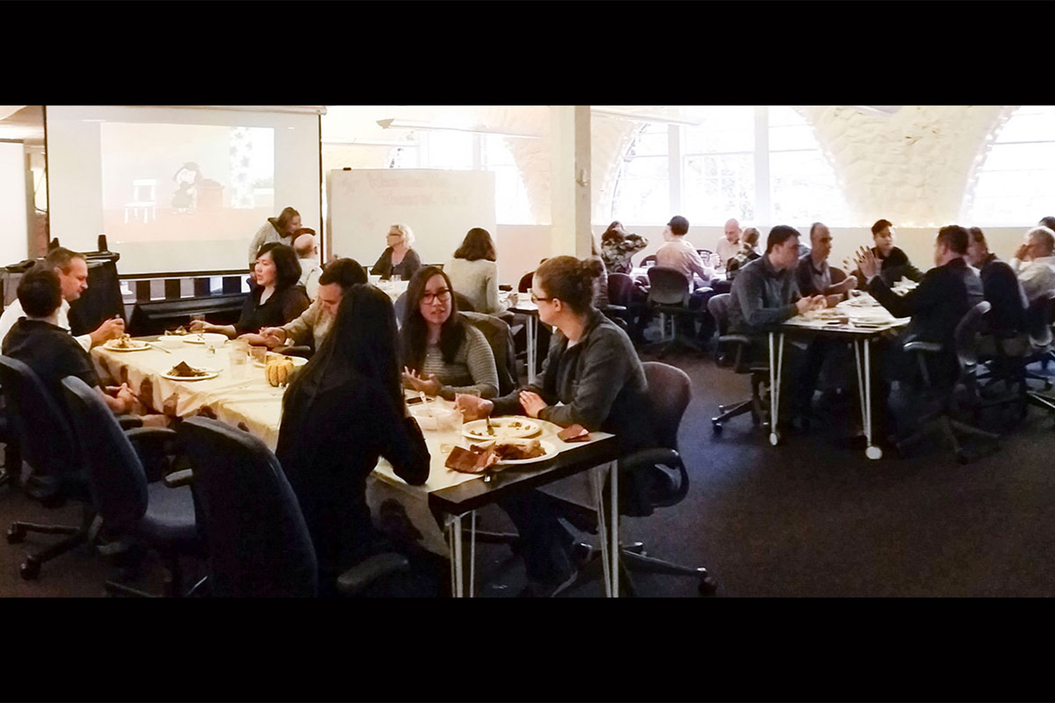 Tocci employees sitting at tables eating Thanksgiving food 