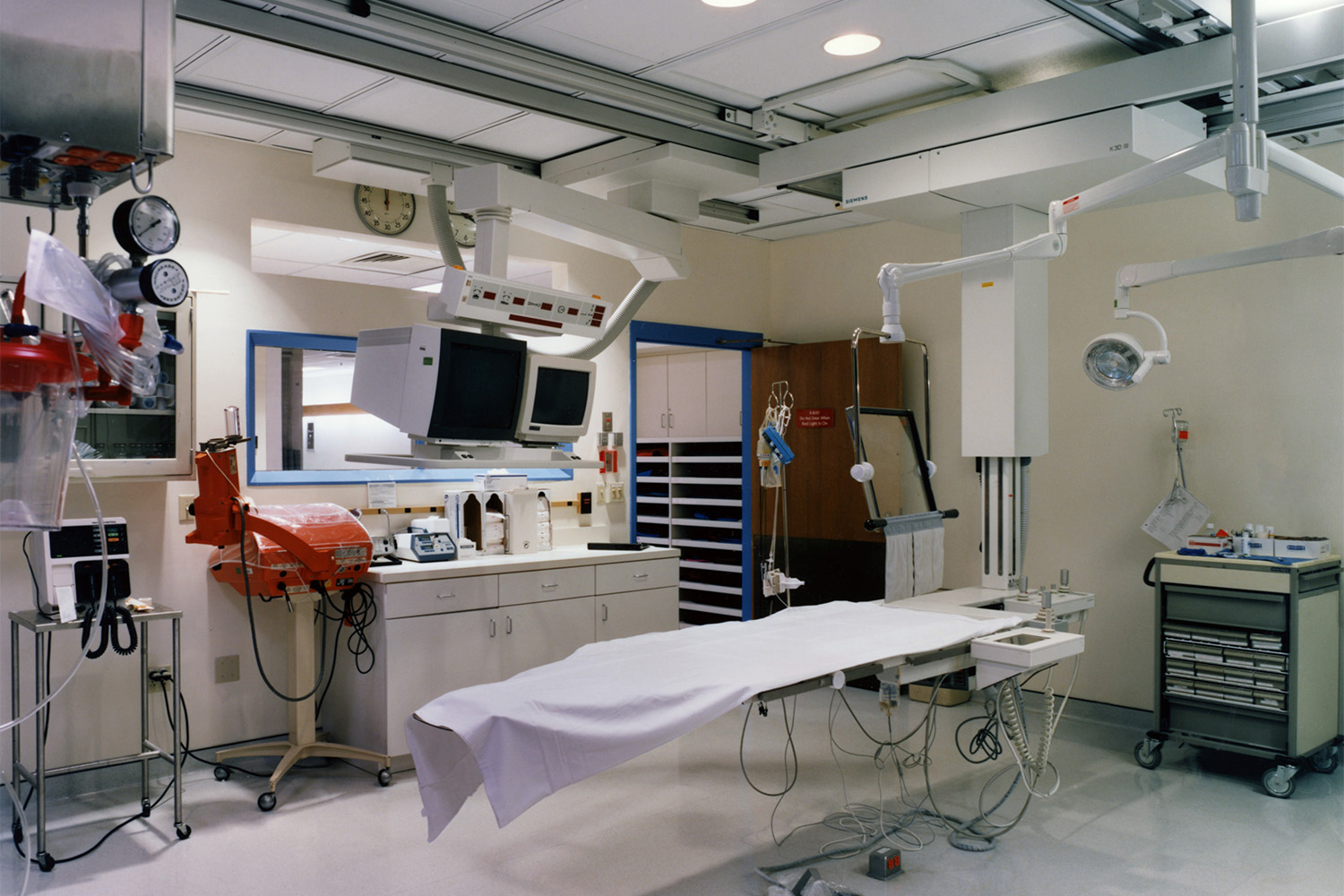 surgical room with operation bed, and various hanging equipment 