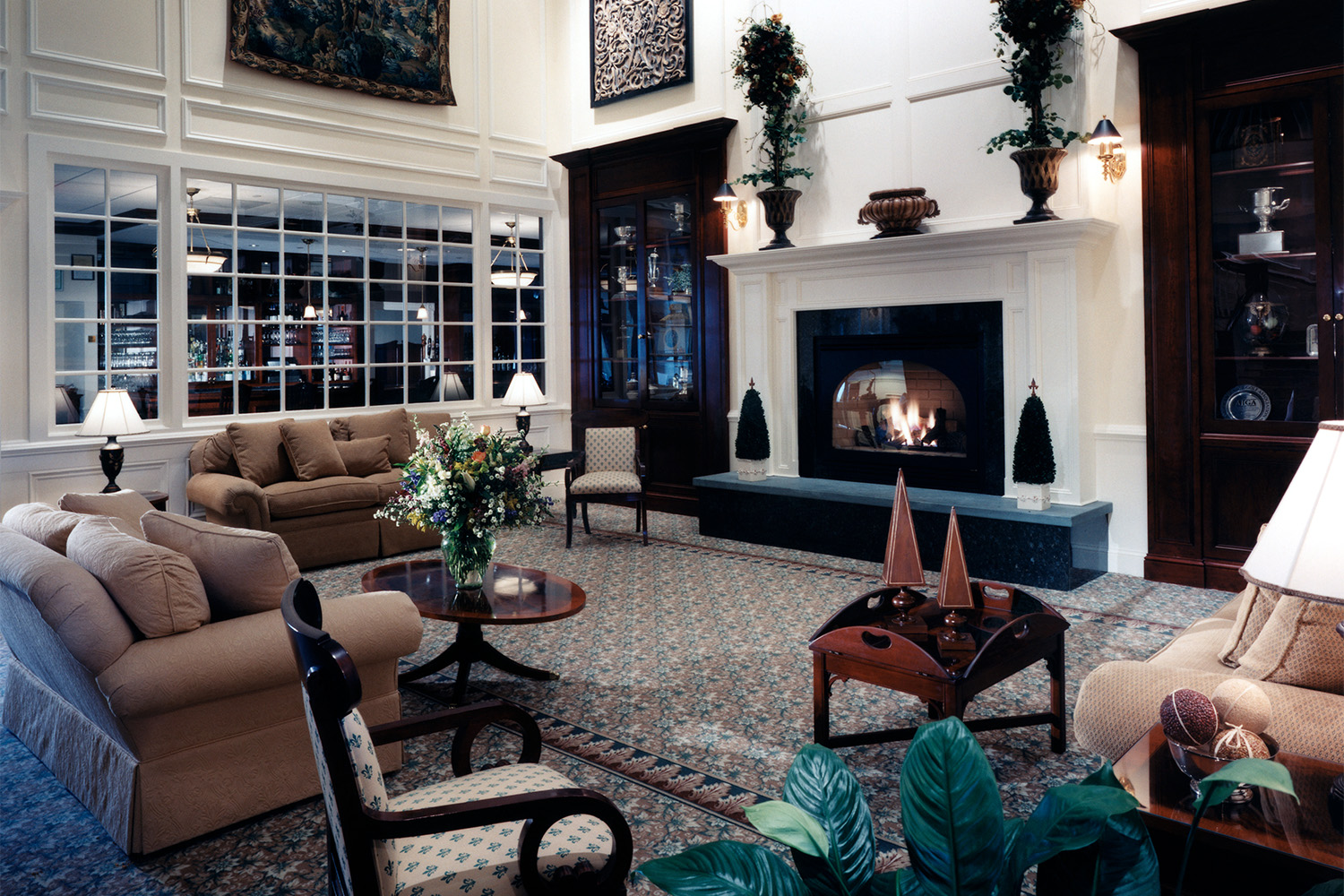 lounge area of clubhouse with several windows, and a fireplace in the center 